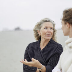 Senior woman talking to adult daughter on the beach