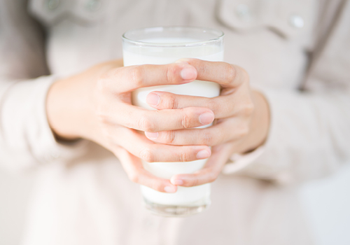 vrouwenhanden houden glas melk vast