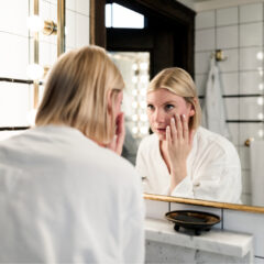 Vrouw-kijkt-in-spiegel-in-badjas-1